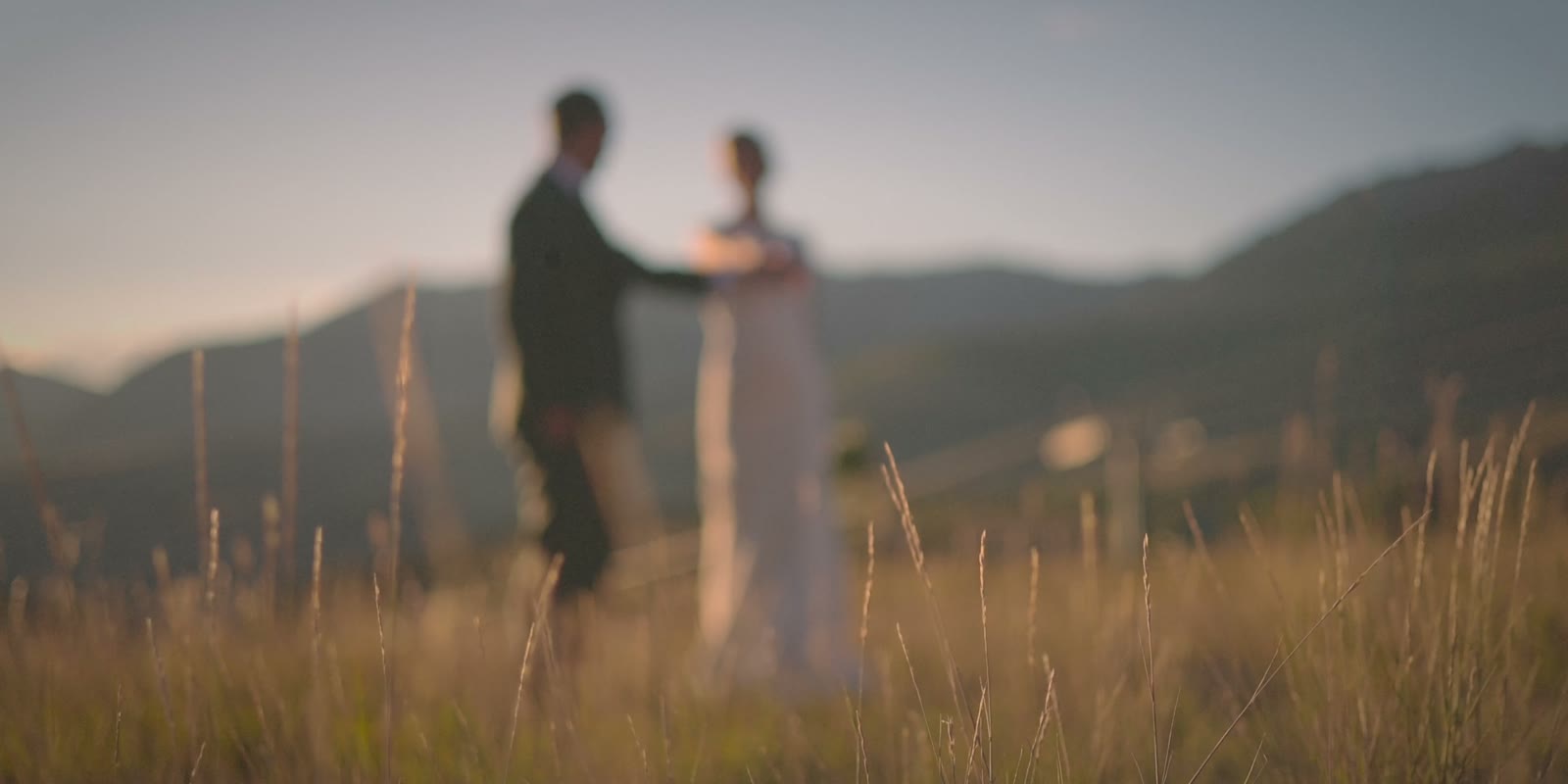 Sydney and Chad in tall grass at golden hour